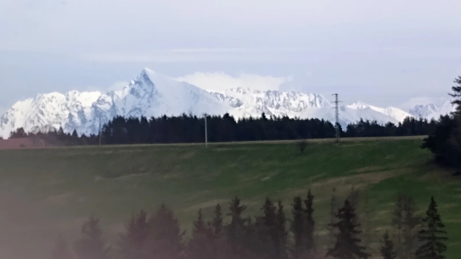 Zasnežený Kriváň nad lúkami a lesmi, pohľad od obce Jamník